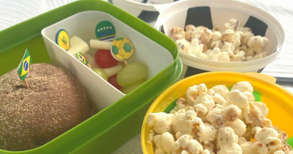 Lanche da copa com pipoca, frutas e pão australiano